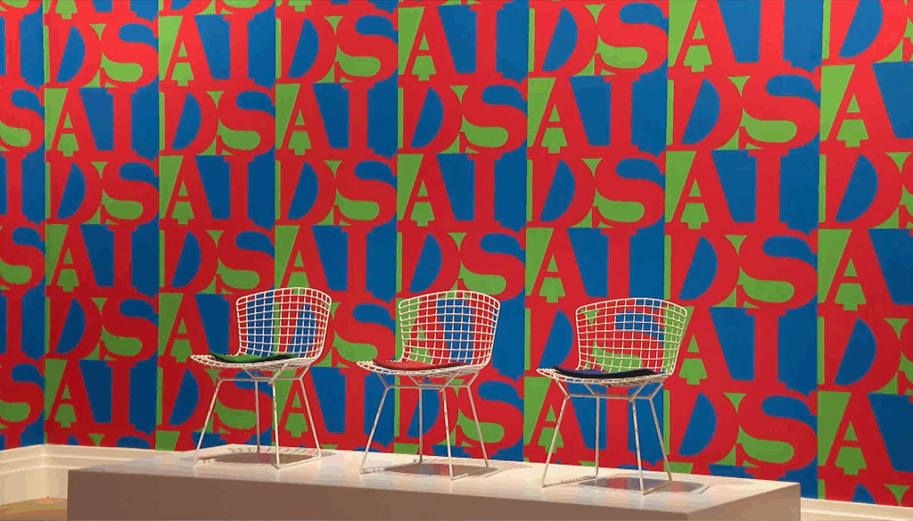 Three design chairs in front of a colourful wallpaper